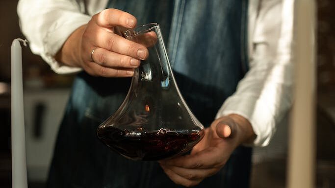 A Person Holding a Wine Decanter