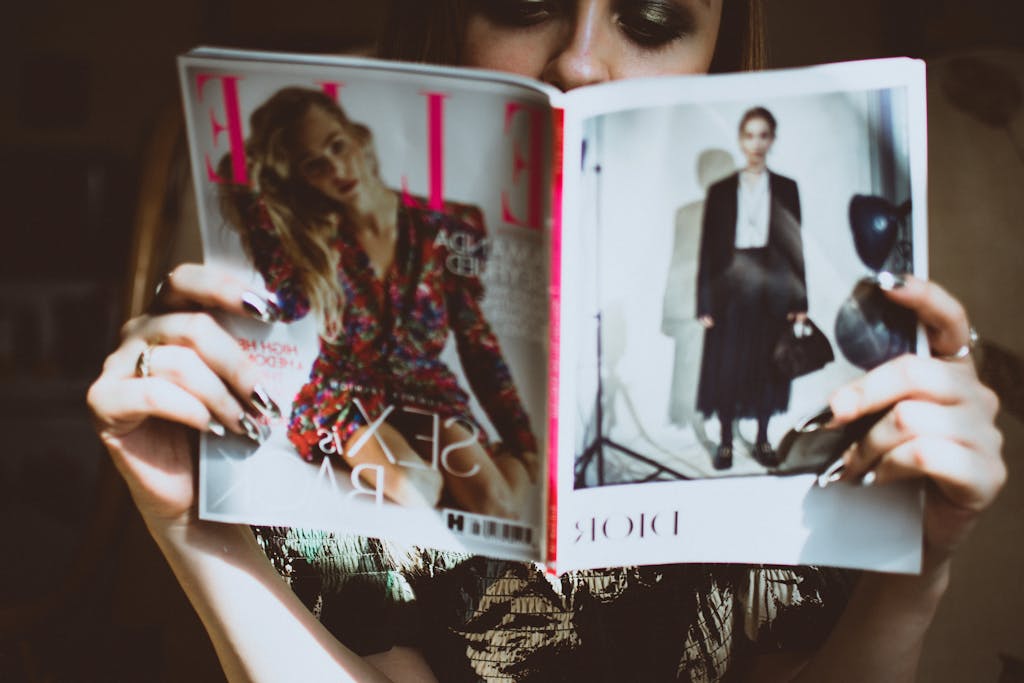 Woman Sitting on Chair While Reading magazine